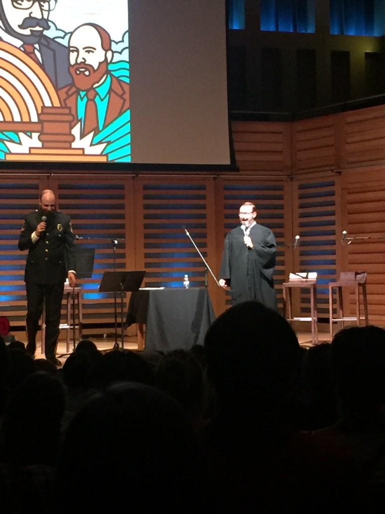 John Hodgman on stage in a judge costume