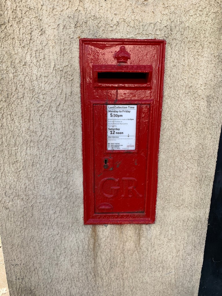 A red postbox in a wall