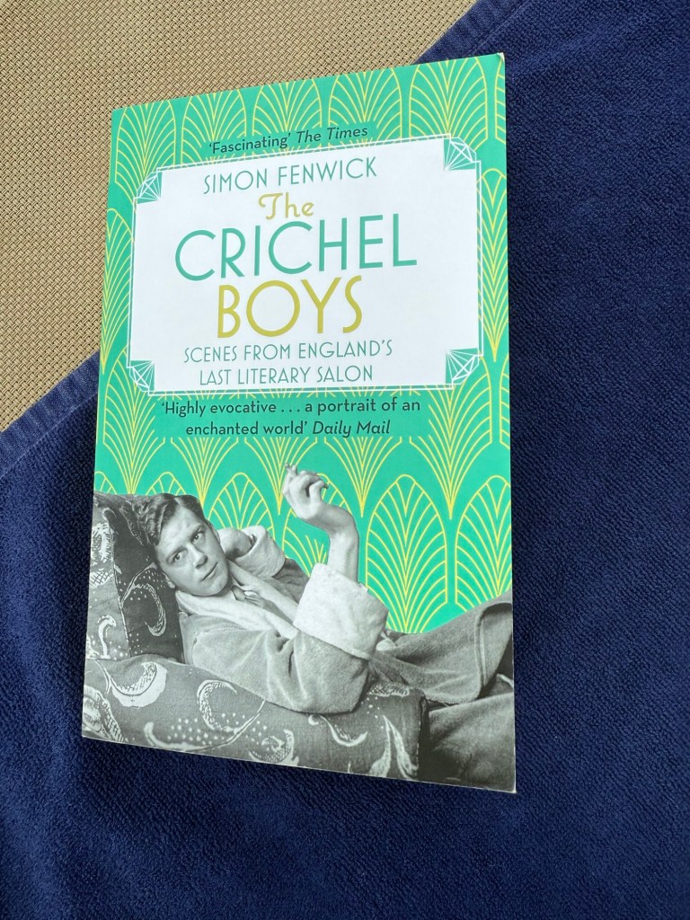 paperback copy of The Crichel Boys on a sun lounger